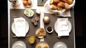 Eixord ambient amb plats, coberts, tetera, fruita, pastissos i condiments.