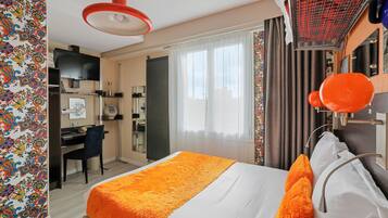 A hotel room with a bed, a desk, a chair, and a television.