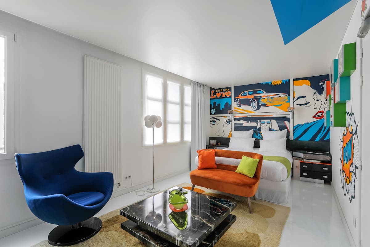 A modern living room with a blue chair, orange sofa, and a coffee table.