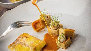 A plated dish with a sauce being poured over it.