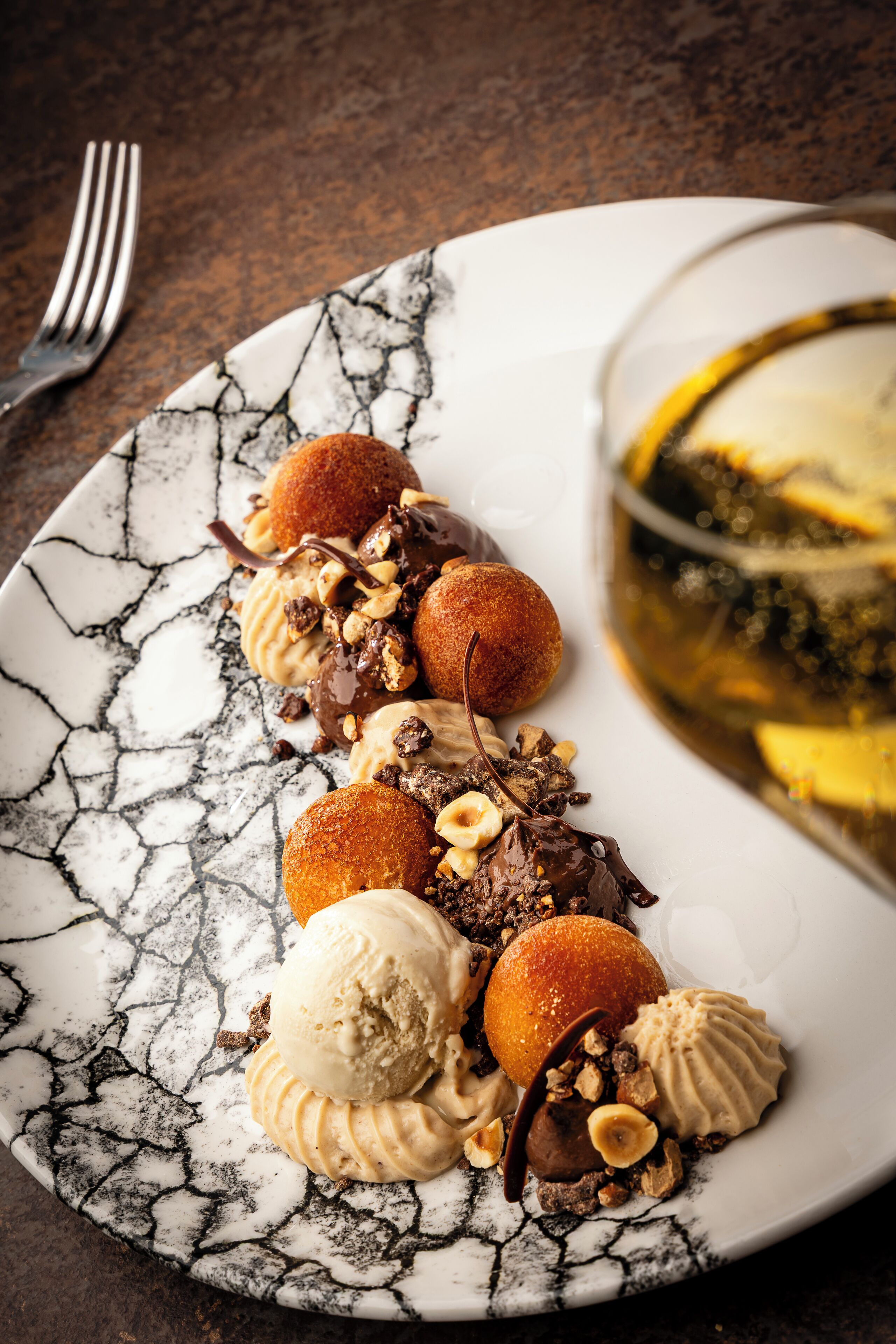 Une assiette de desserts avec divers types de douceurs et un verre de vin.