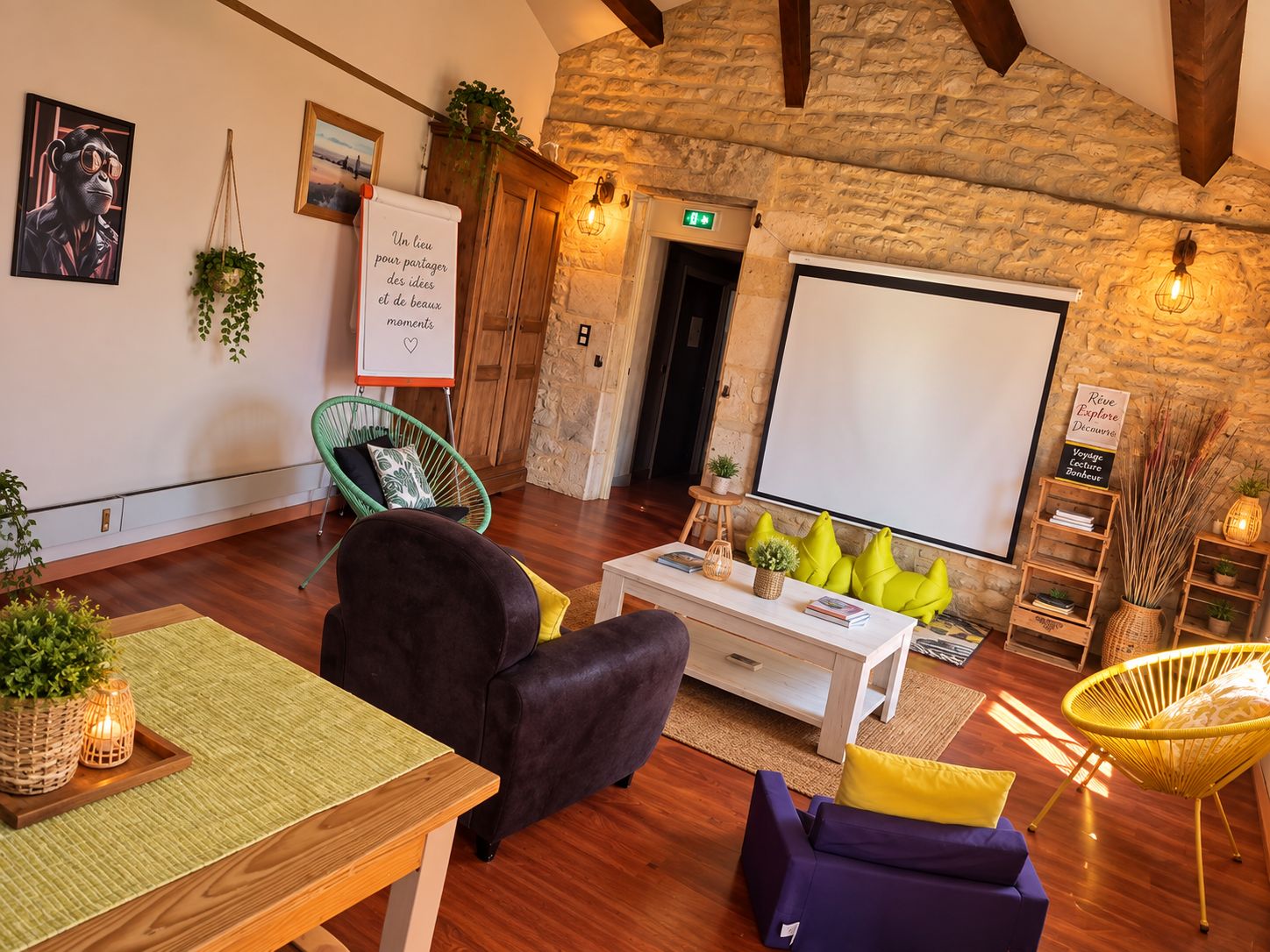 A cozy room with a stone wall, a whiteboard, a projector screen, and comfortable seating.