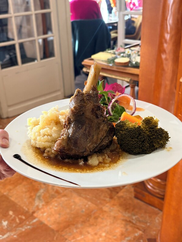 A plate with a lamb shank, mashed potatoes, and broccoli. - Le Lion d'Or (Gramat)