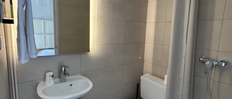 A bathroom with a sink, toilet, and shower.