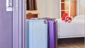 Habitació d'hotel amb una llitera, un escriptori i dues maletes.