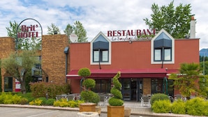 A restaurant with a red awning and a sign that reads "RESTAURANT Le Bouchard des Savoire." - Brit Hotel Chambery (Chambery)