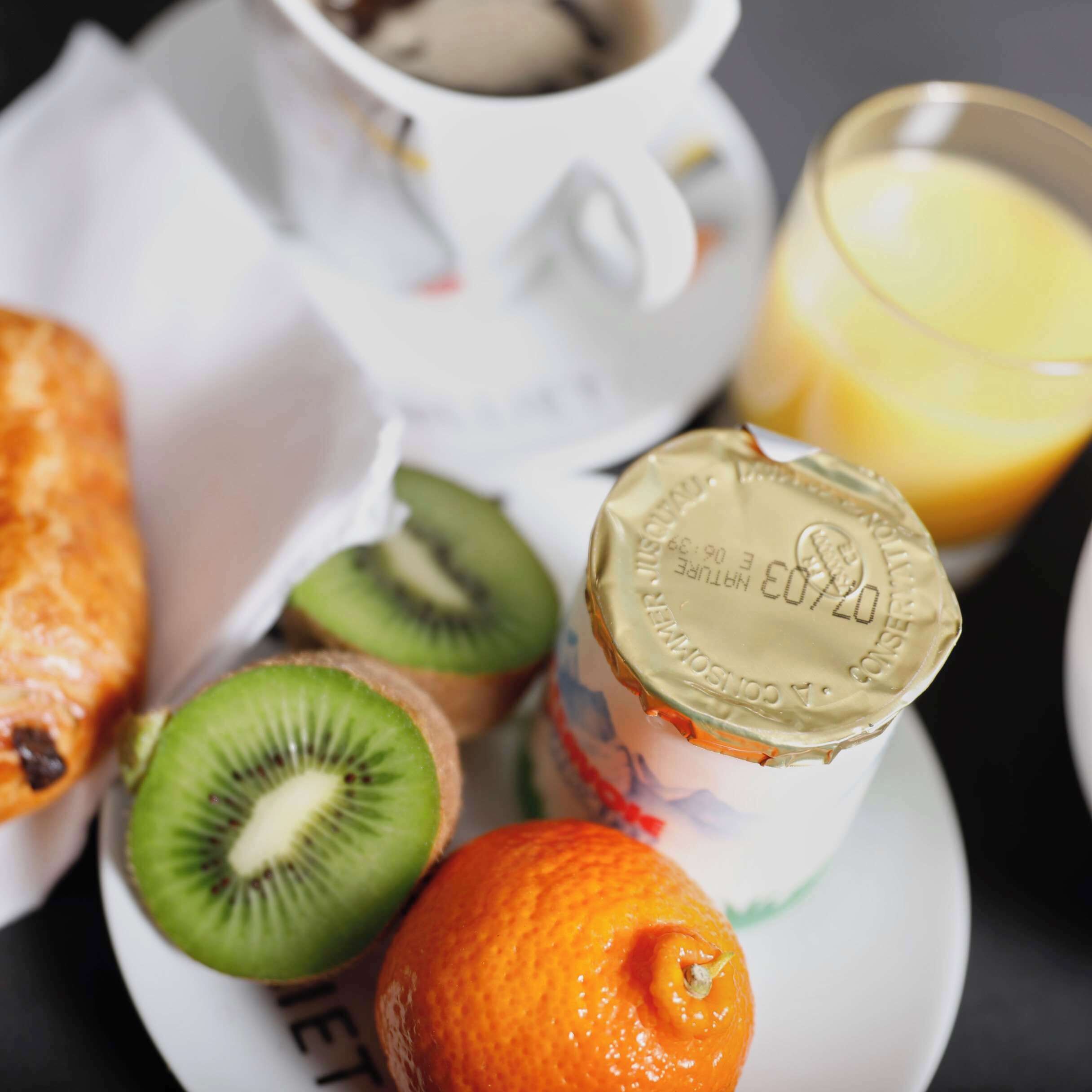 A breakfast setting with a plate of food, a cup of coffee, and a glass of orange juice.