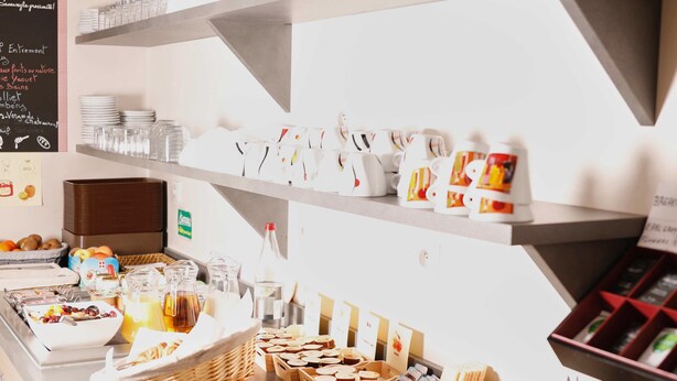 A buffet setup with various food items and utensils. - Brit Hotel Chambery (Chambery)