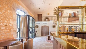 Una zona de bar con un expositor de vidrio, paredes de piedra y una puerta de madera.