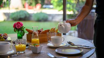 Une table de petit-déjeuner avec des croissants, une théière et une tasse de café.