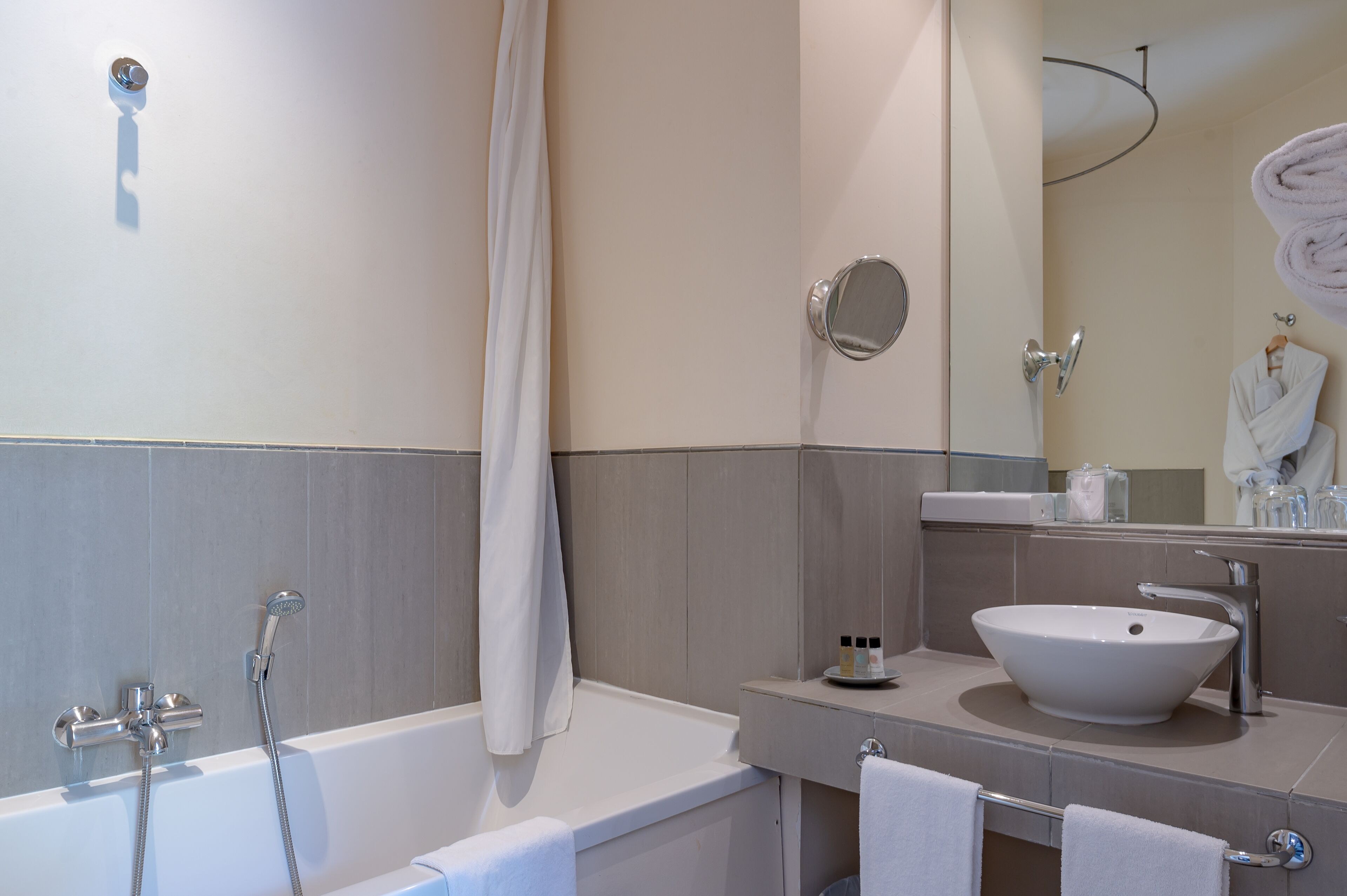 Une salle de bain moderne avec une baignoire, un lavabo et un miroir.