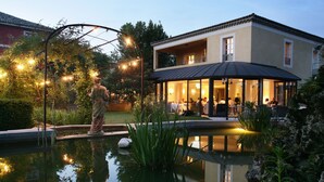 A house with a pool, outdoor seating, and string lights. - Villa Augusta (Saint-Paul-Trois-Chateaux)