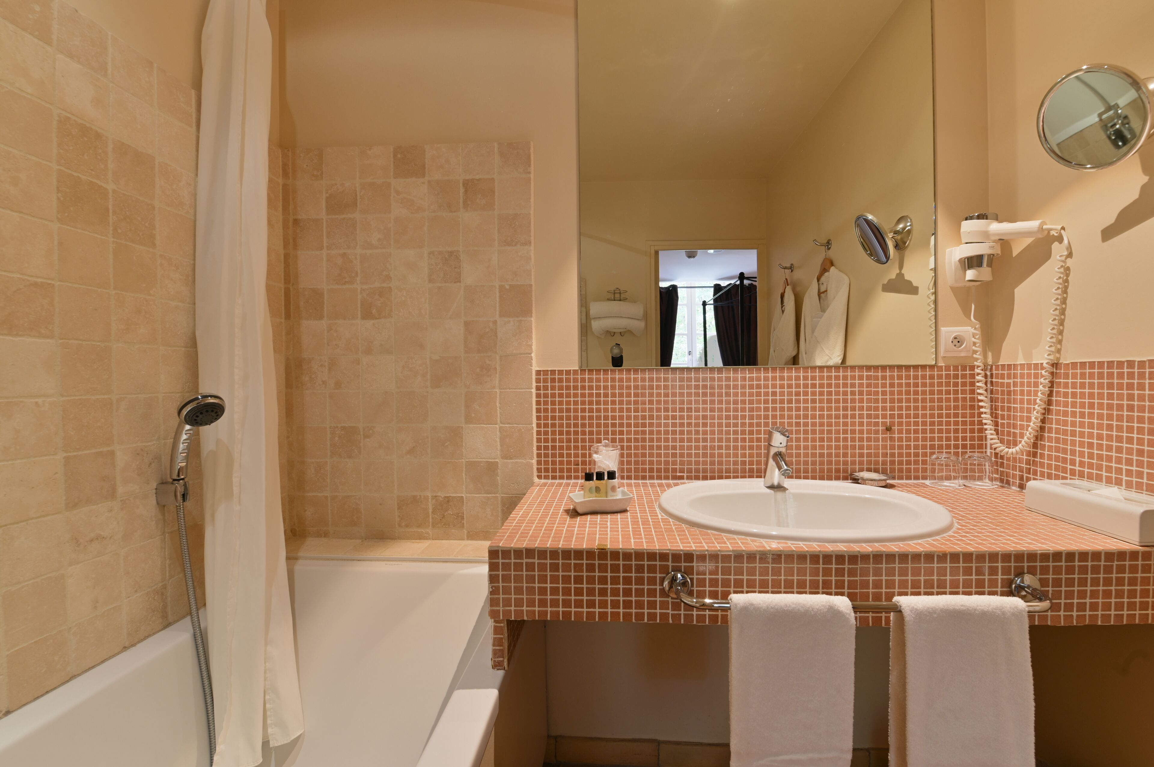 Een badkamer met een bad, een wastafel en een spiegel.