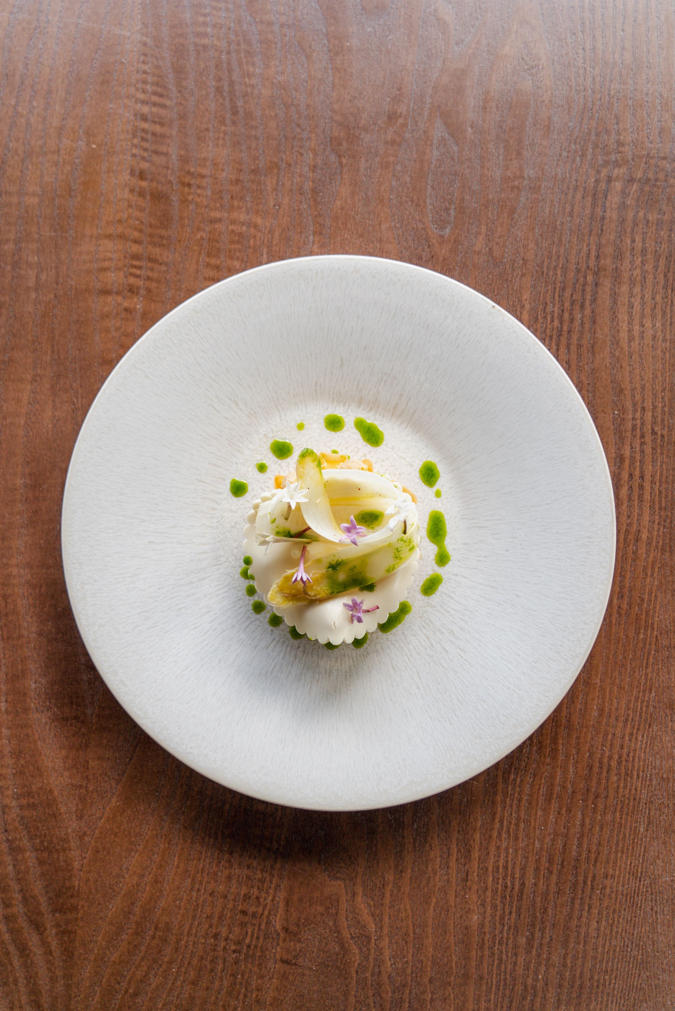 A white plate with a dessert on a wooden table.