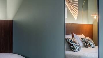 A bedroom with a bed, a large mirror, and a hanging fan.