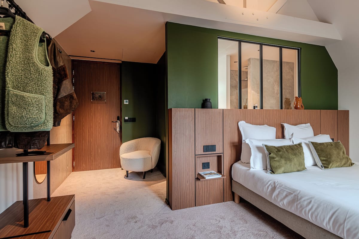 A bedroom with a bed, bedside tables, a chair, and a wardrobe.