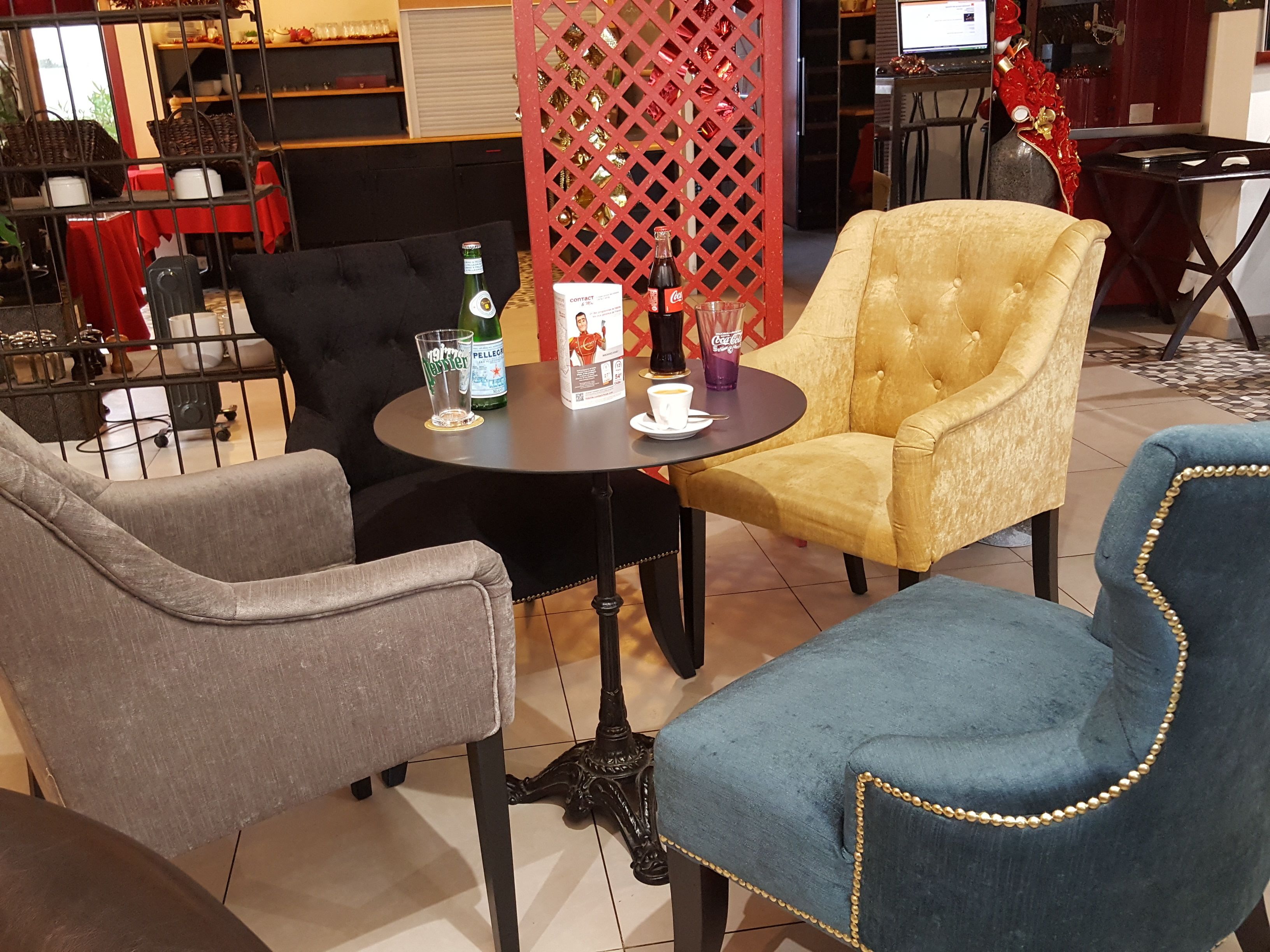 A seating area with a round table, chairs, and a decorative red lattice partition.