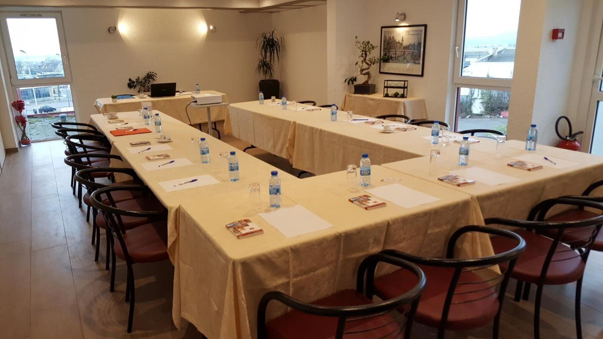 A conference room with long tables, chairs, water bottles, and nameplates.