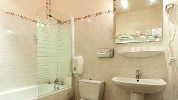 A bathroom with a toilet, sink, and shower.