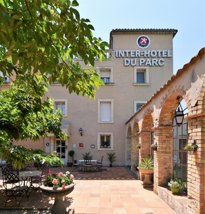 An Inter-Hotel Du Parc with a courtyard featuring outdoor seating and potted plants. - The Originals City, Hôtel du Parc, Avignon Est (Entraigues-sur-la-Sorgue)