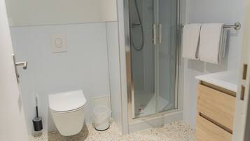 Un baño con inodoro, ducha y lavamanos.