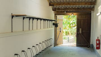 A corridor with a tiled ceiling, a wooden door at the end, and a fire extinguisher on the wall.