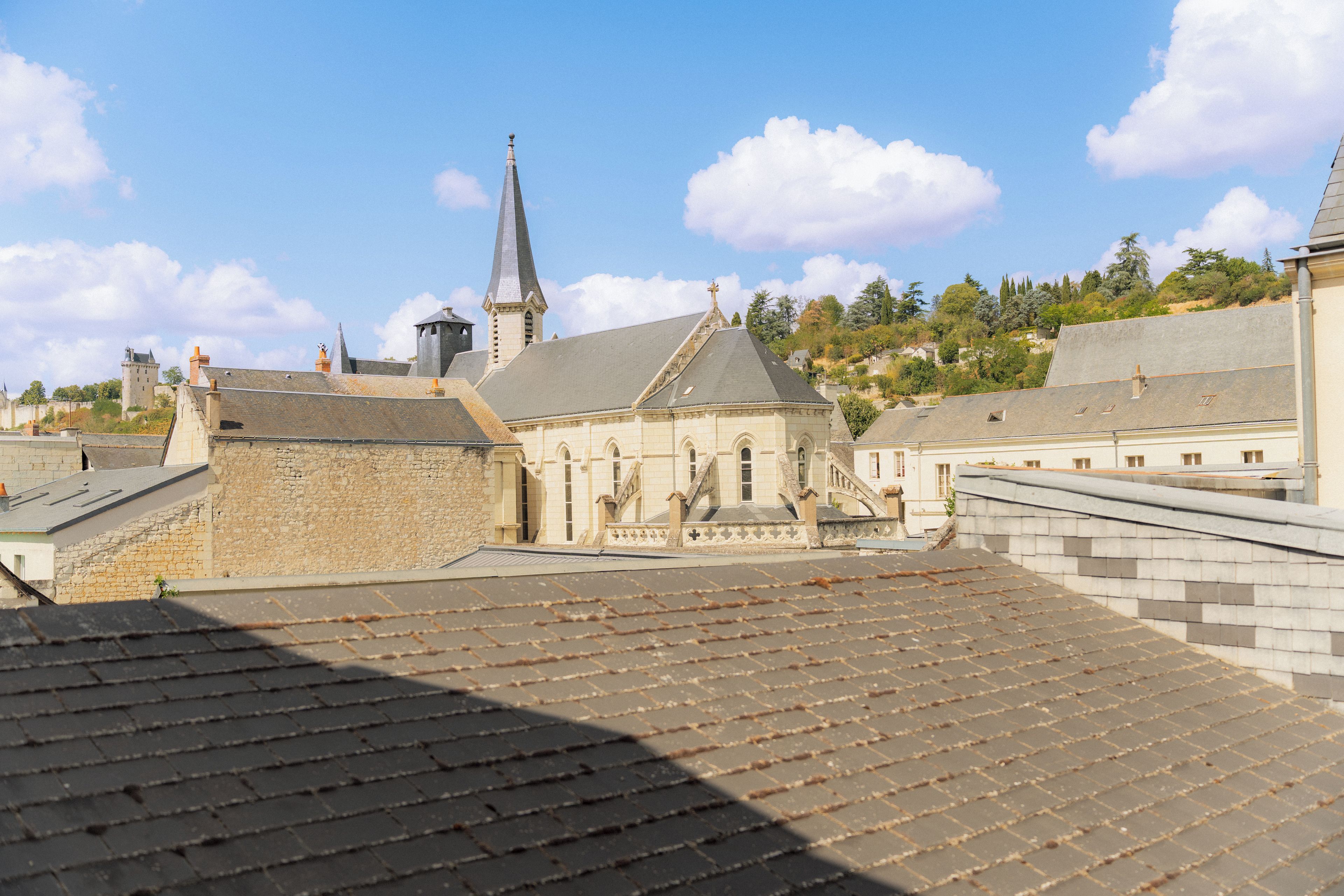 A historical building with a prominent tower and a smaller adjacent structure, both featuring classic architectural elements.