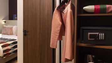 Une chambre d’hôtel équipée d’un lit, d’une armoire et d’un four à micro-ondes posé sur le plan de travail.