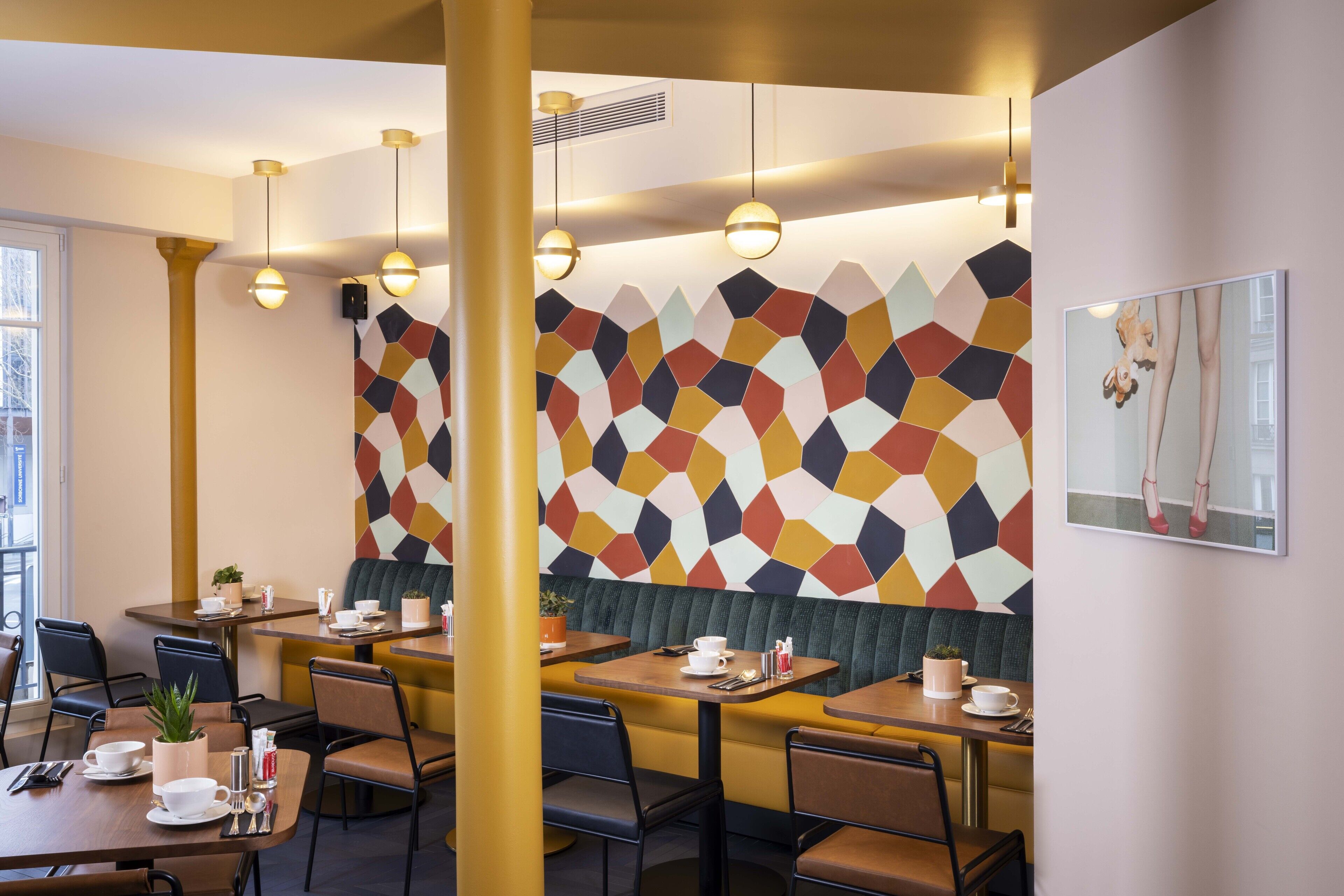 Un comedor moderno con paredes de diseño geométrico, varias mesas y sillas.