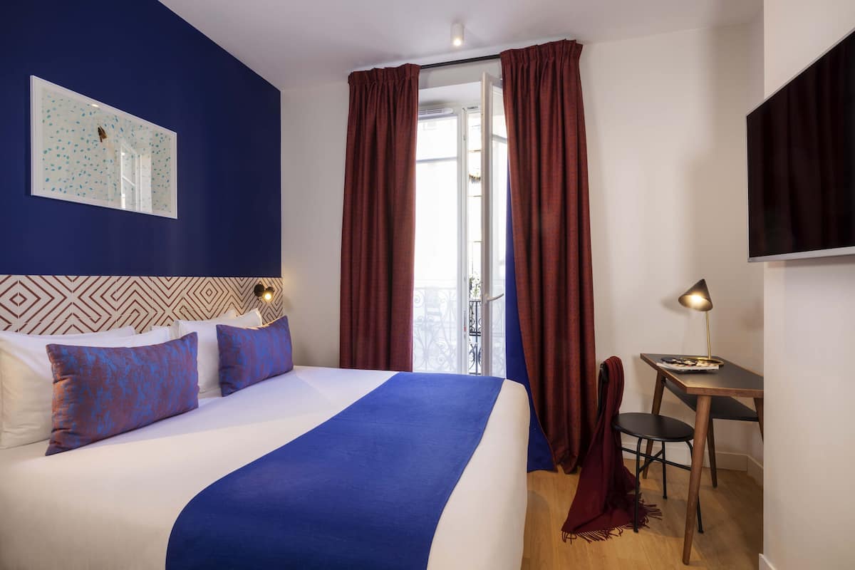 Ein Hotelzimmer mit Bett, Schreibtisch und Stuhl.