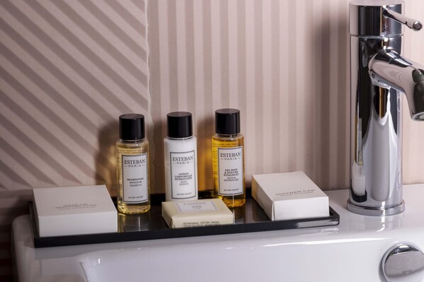 Un estante de baño con tres productos Estevan Paris y dos cajas.