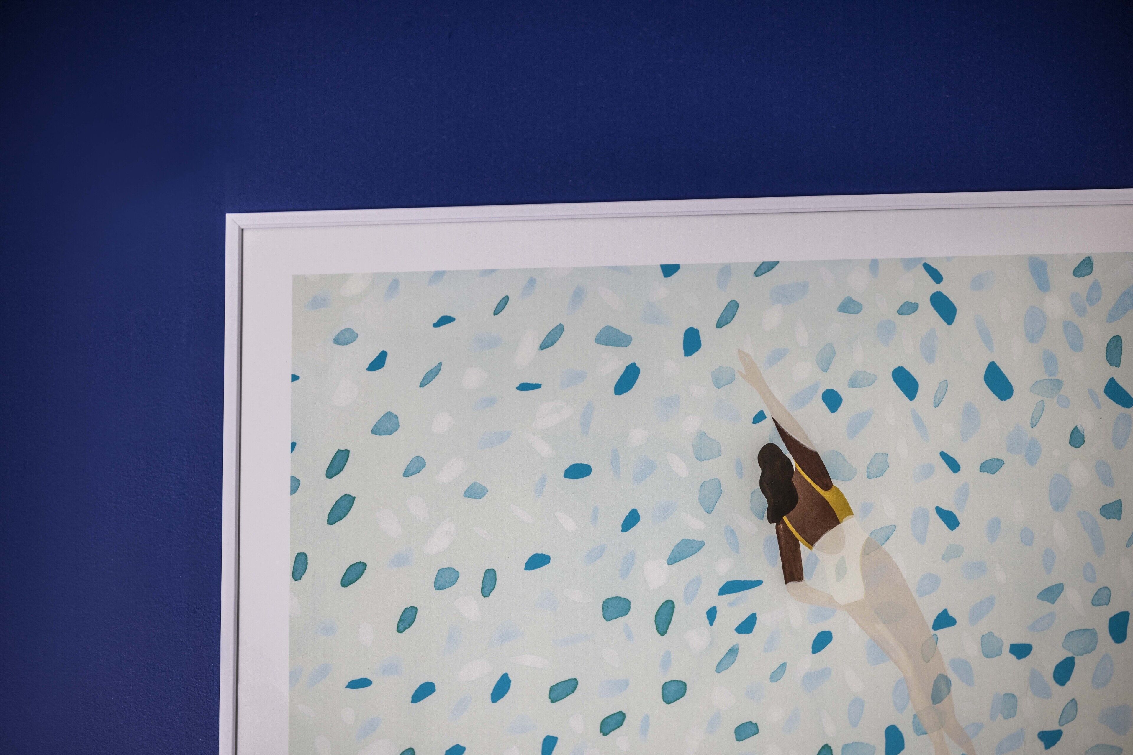 Una obra de arte enmarcada con fondo azul y una figura vestida de blanco.