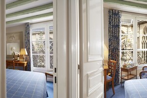 Ein Hotelzimmer mit Bett, Schreibtisch, Stuhl und Fenster mit Stadtblick.