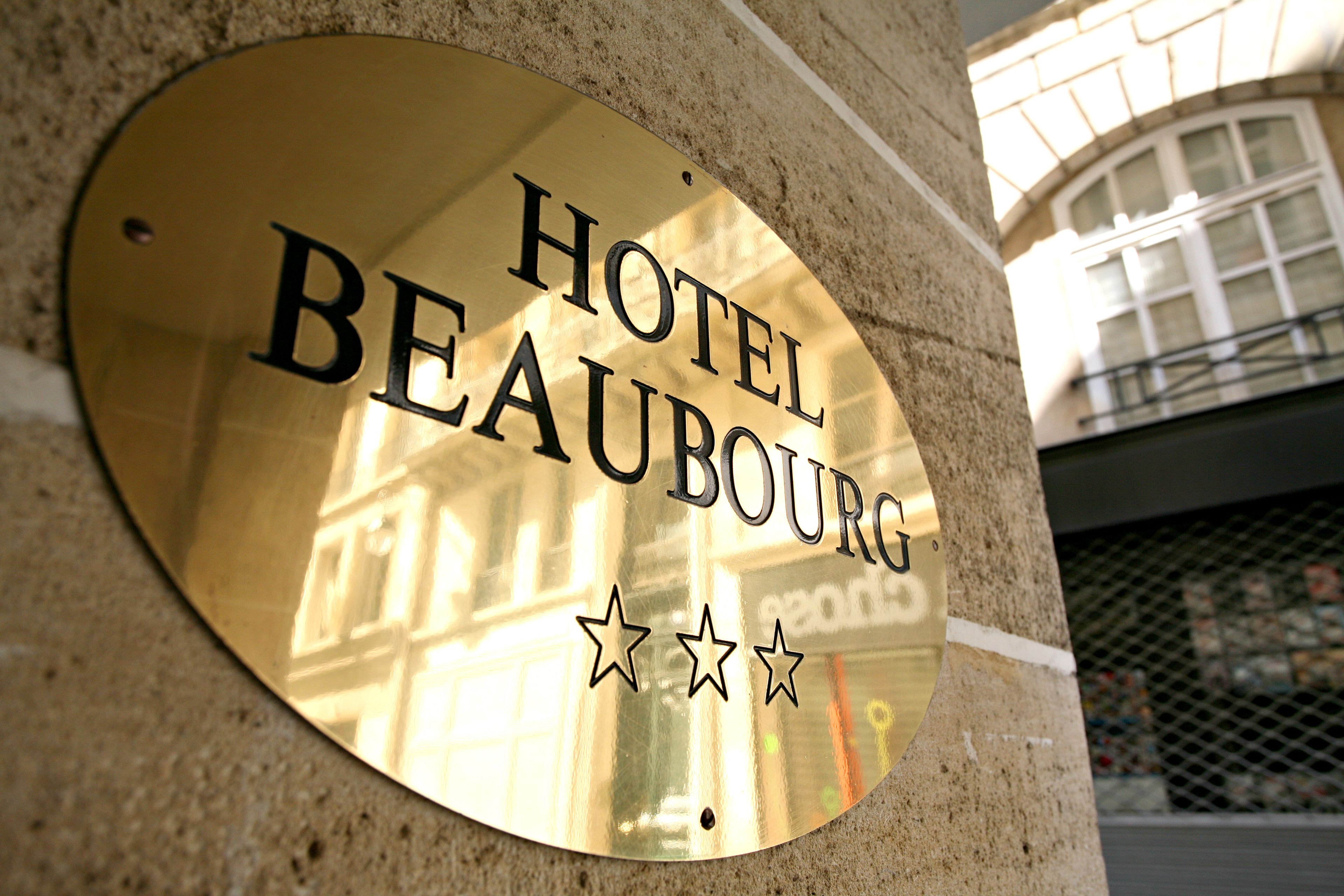 Una placa dorada con el texto 'HOTEL BEAUBOURG' y tres estrellas.