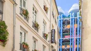 A hotel facade with multiple windows, some with flower boxes, and a sign reading "HOTEL BEAUBOUG". - Hotel Beaubourg (Paris)