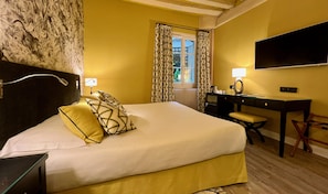 A hotel room with a large bed, a desk, and a television. - Hotel Beaubourg (Paris)