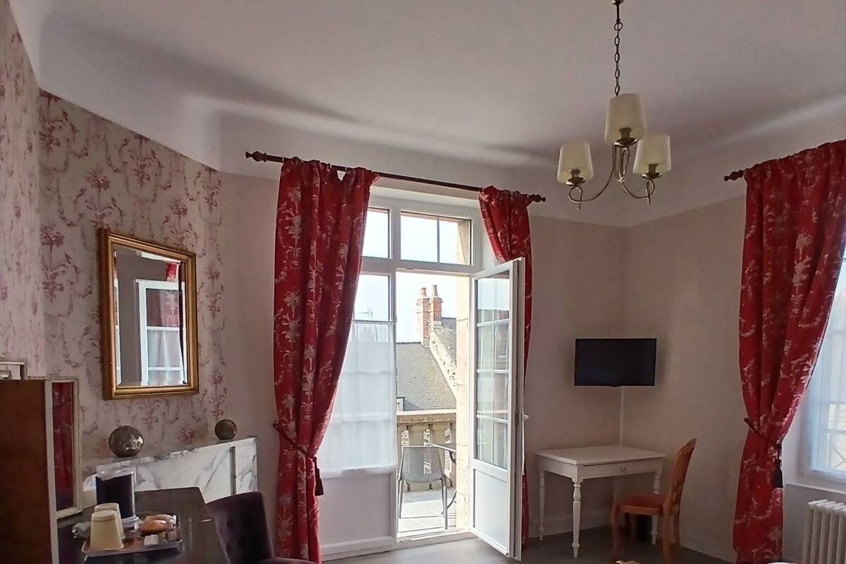 Een hotelkamer met een bed, bureau, stoel en uitzicht.