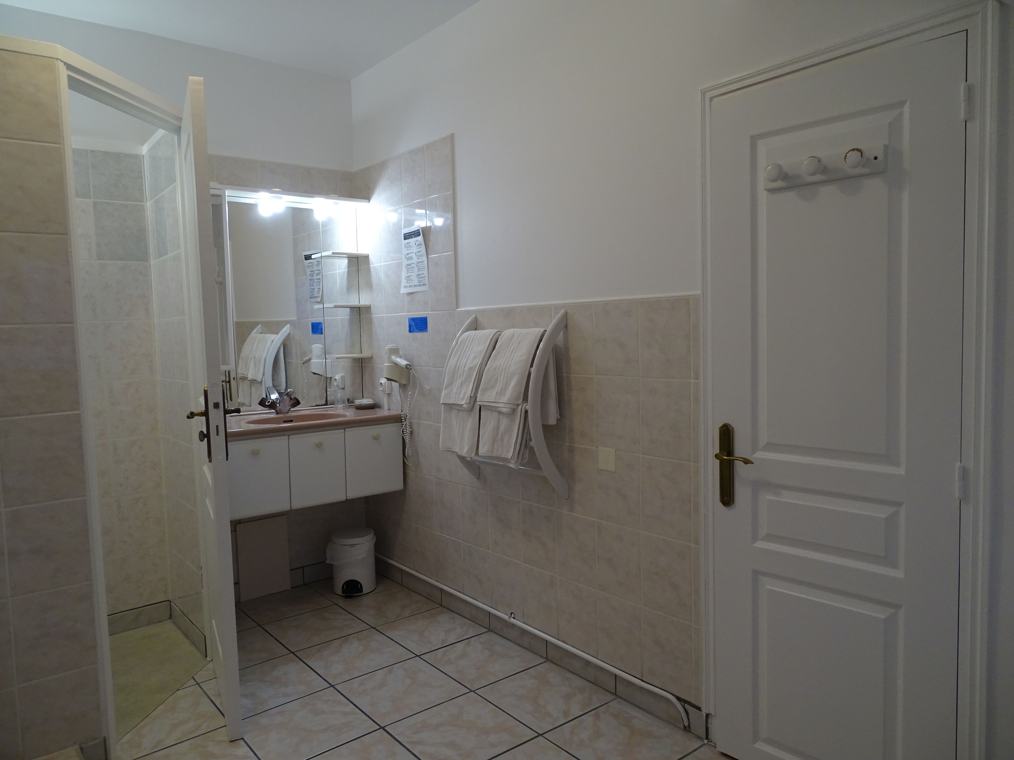 A bathroom with a sink, mirror, towel rack, and toilet.