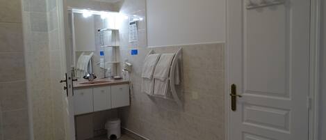 A bathroom with a sink, mirror, towel rack, and toilet.