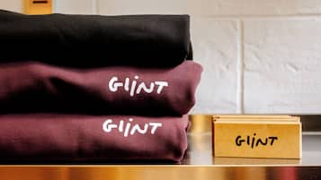 A stack of folded blankets labeled 'GLINT' on a wooden surface.