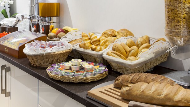 Un buffet proposant une variété de pains, de viennoiseries et de produits laitiers.