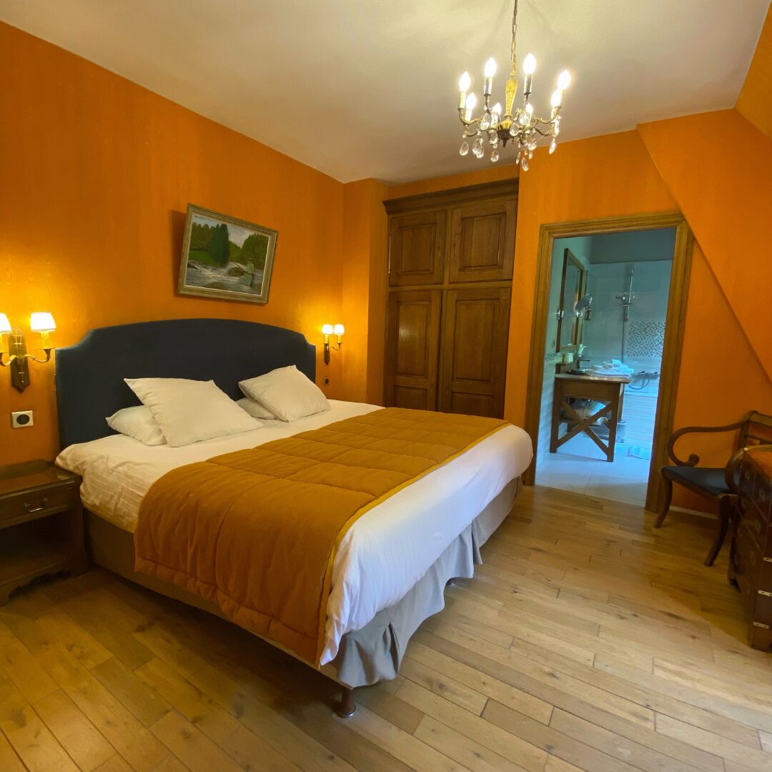 Ein Schlafzimmer mit einem großen Bett, einem Holzschrank und einer Kronleuchter.