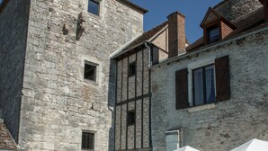 Um edifício de pedra com piscina, área de estar ao ar livre e estilo arquitetônico rústico.