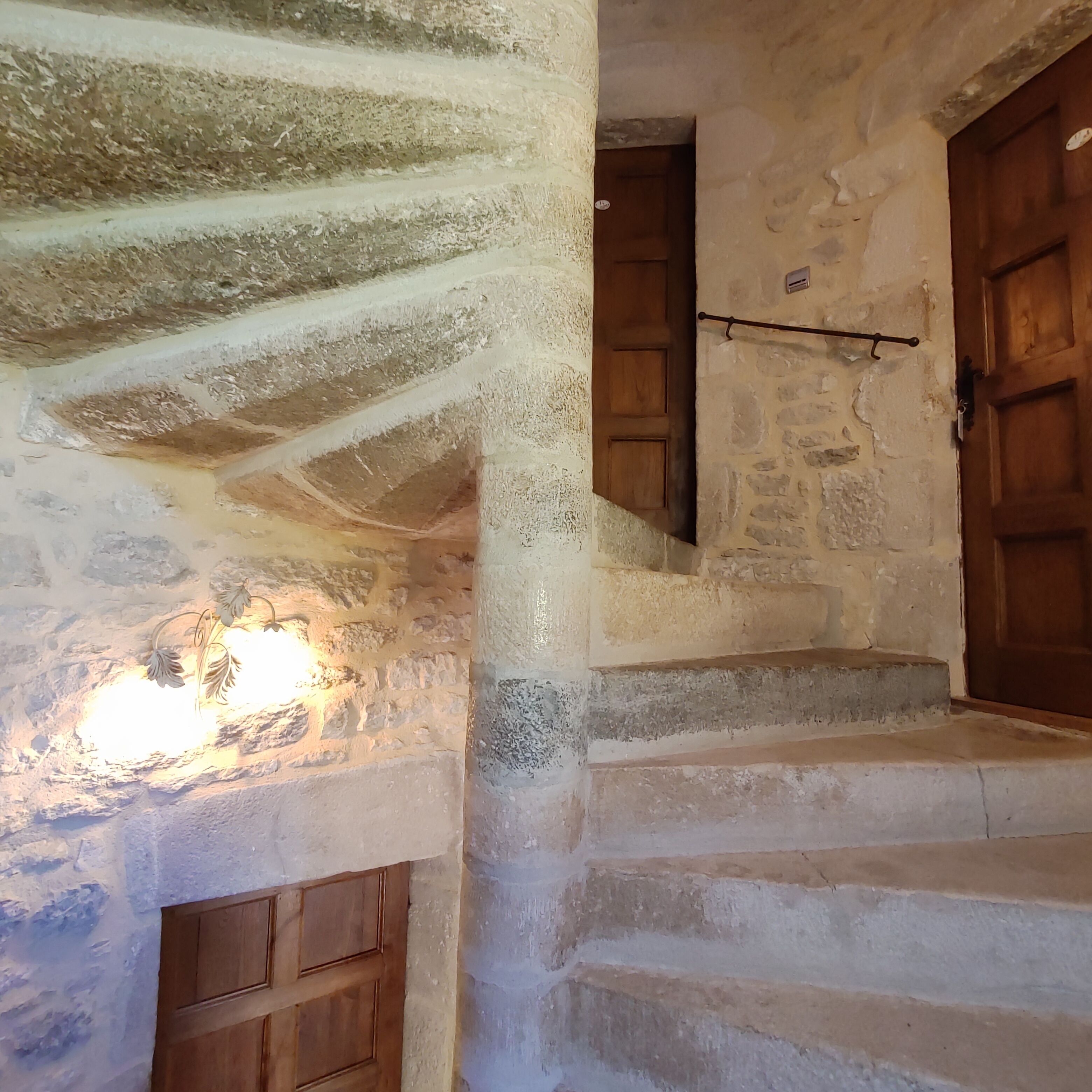 A stone staircase with wooden doors and a light fixture.