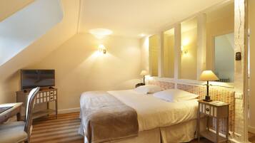 Une chambre à coucher avec un lit, des tables de chevet, une télévision et un miroir.