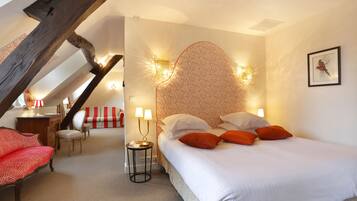 Une chambre à coucher avec un lit, deux lampes de chevet, une chaise, un bureau et un canapé rayé rouge et blanc.