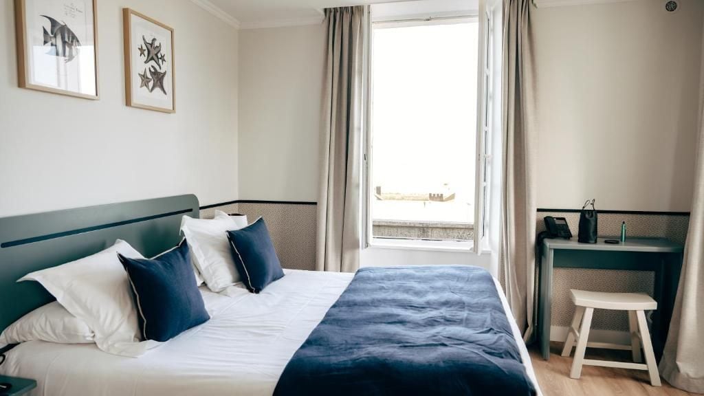 Habitación de hotel con cama, escritorio y vistas al exterior.