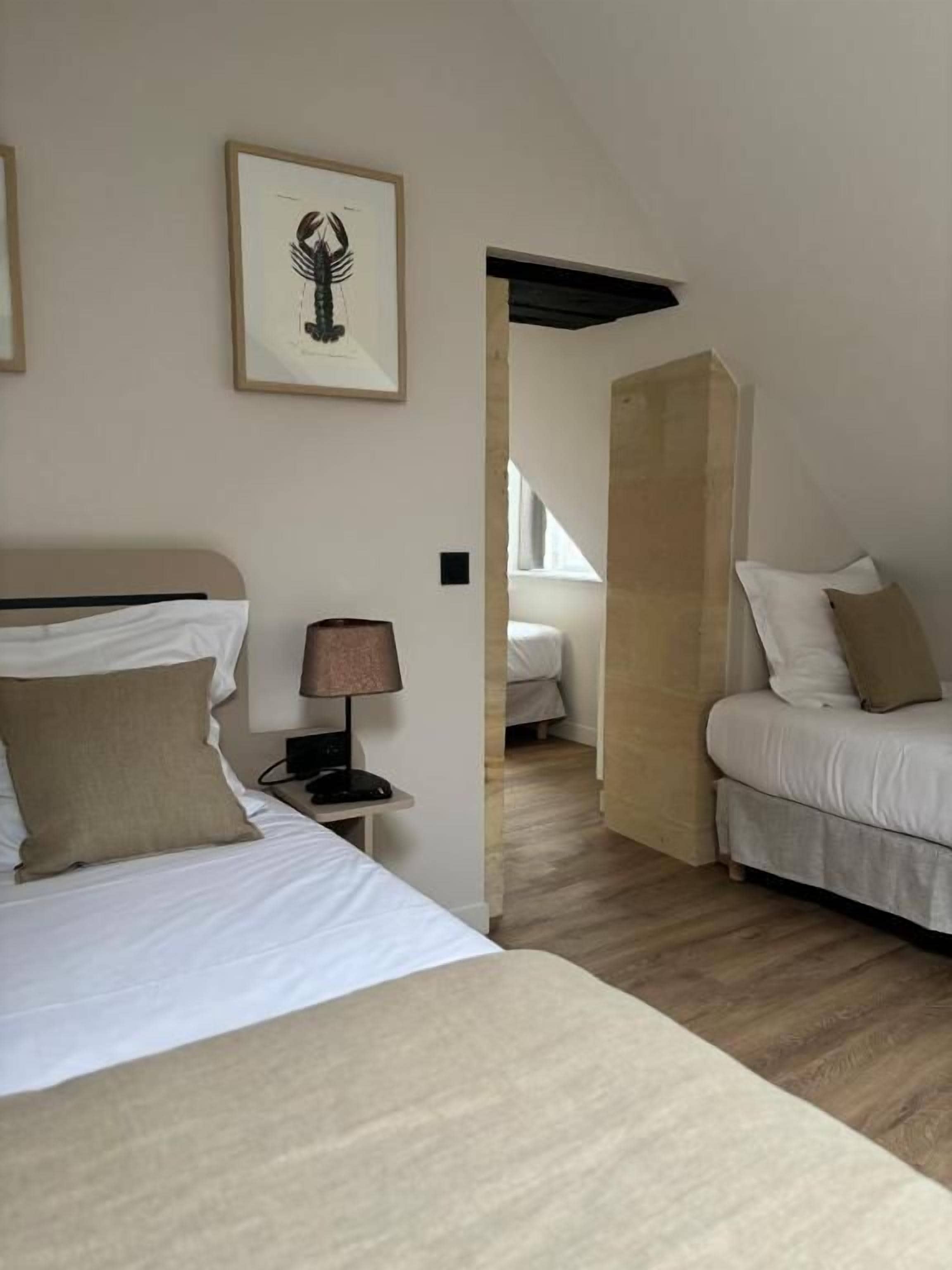A bedroom with a bed, bedside table, lamp, and a framed picture on the wall.