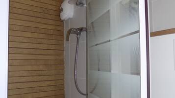 Ducha con pared de paneles de madera, puerta de vidrio y cabezal de ducha.