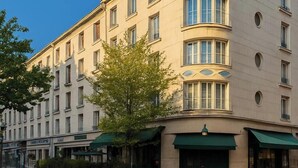 A multi-story hotel with a curved facade, large windows, and green awnings. - Urban Jungle. Hotel Orléans (Orléans)